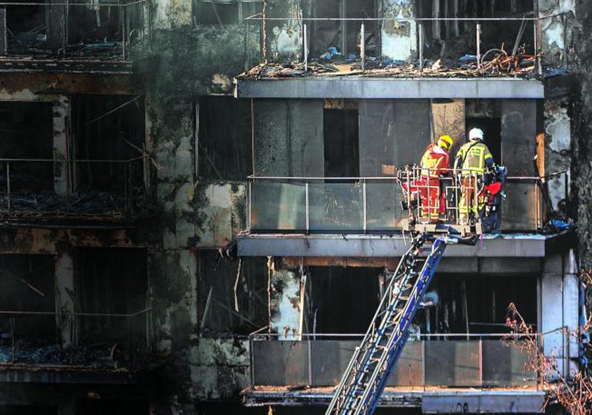 Dos bomberos en la fachada del edificio siniestrado.