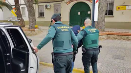 Los agentes acompañan a uno de los detenidos.