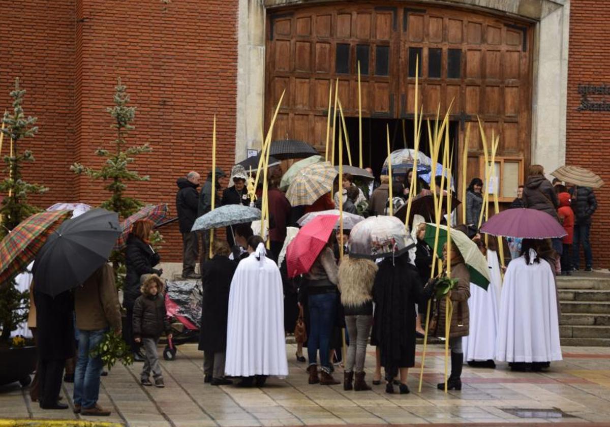 os fieles se cubren con paraguas en Semana Santa.