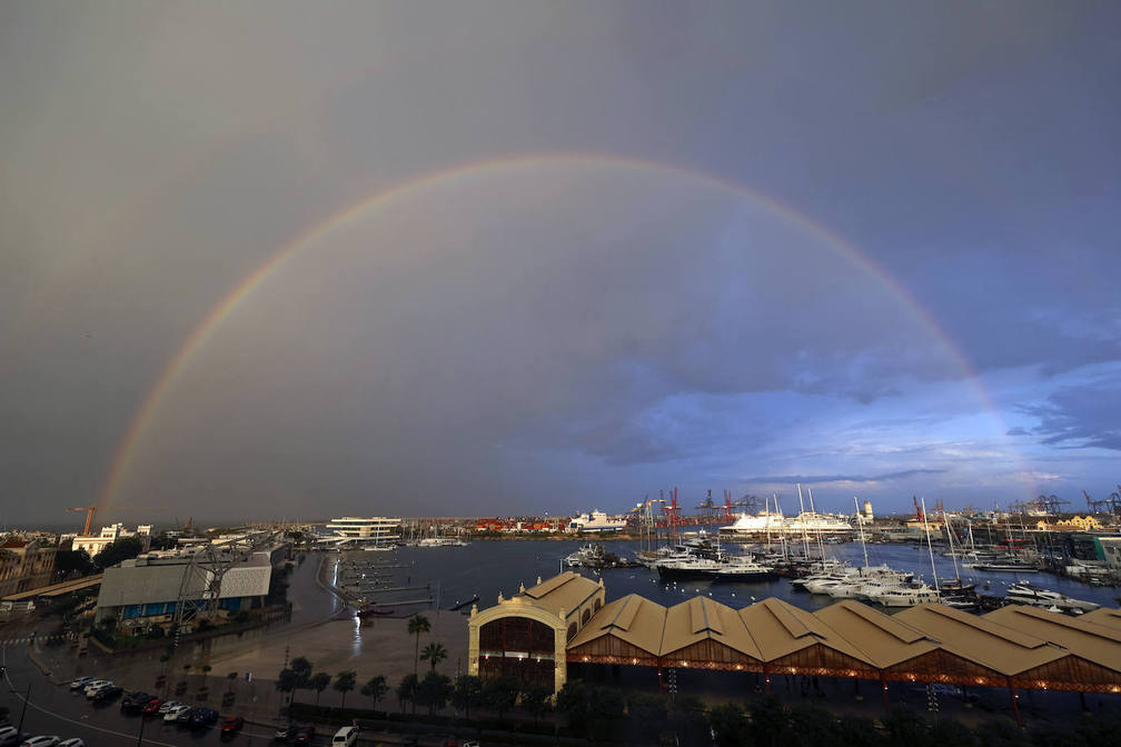 Un arcoíris se despliega sobre la Marina Real, en Valencia.