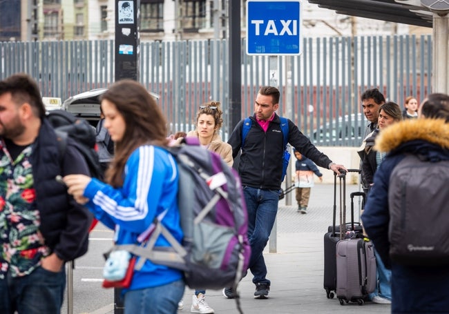 Turistas esperan la llegada de taxis en la parada de la Estación Joaquín Sorolla.