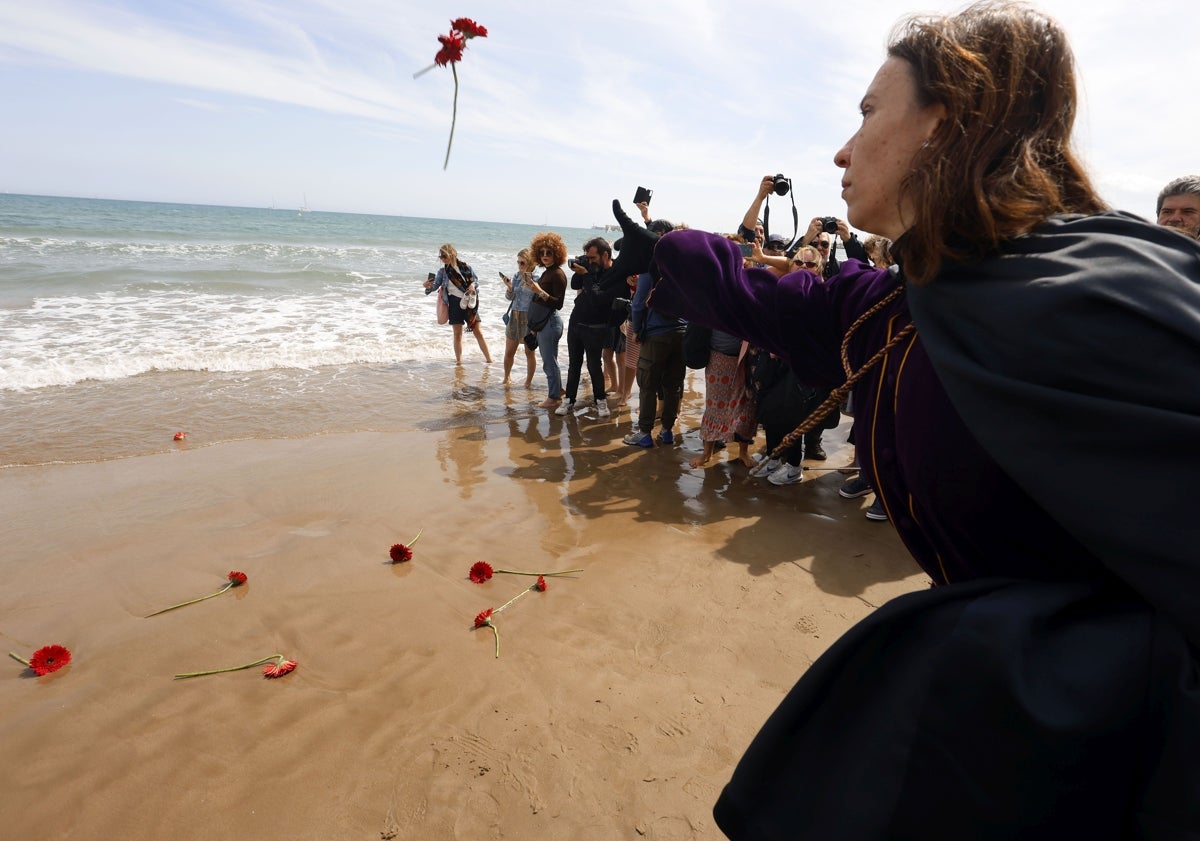 Imagen principal - Ofrenda floral, público realizando fotos y párroco de Cristo redentor-San Rafael y mujer, de nombre Desireé Navarro, llevando al Cristo del Salvador y del Amparo. 