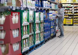 Un hombre compara precios en un supermercado en una imagen de archivo.