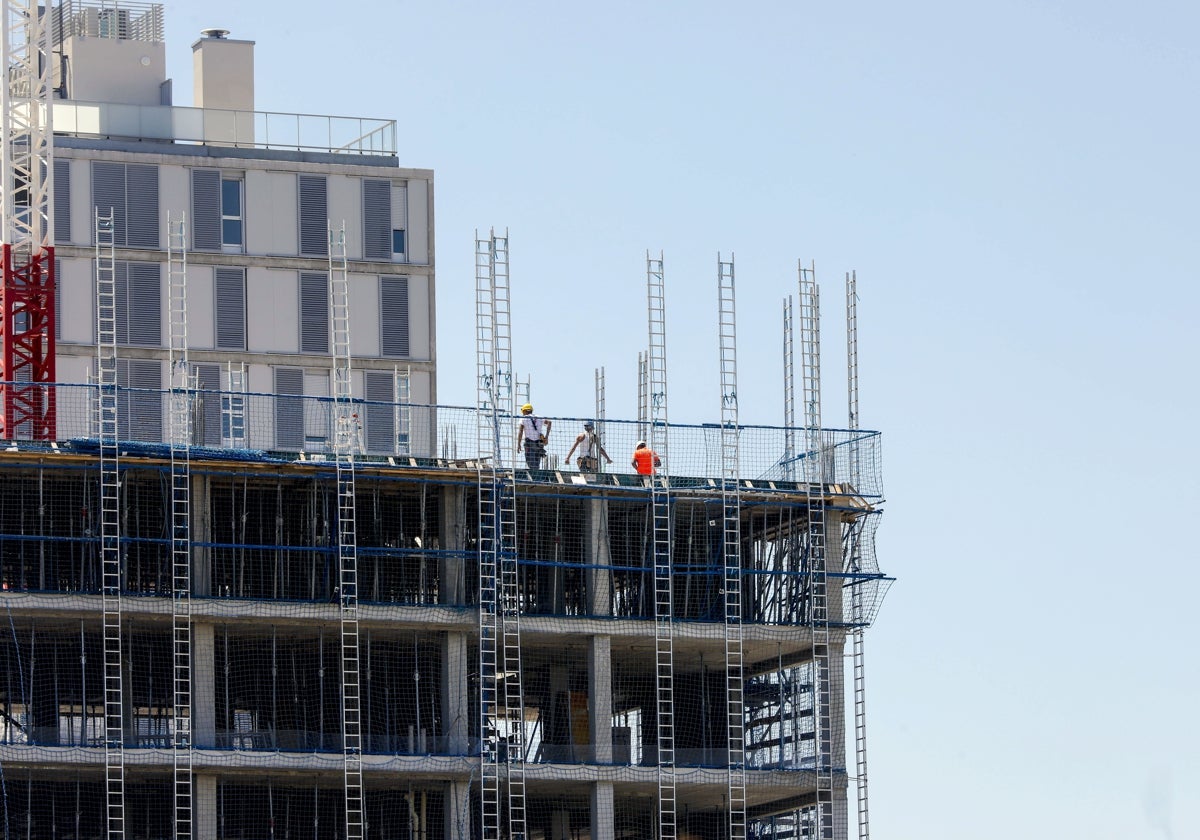 Varios operarios en la parte superior de un edificio en construcción en Malilla.