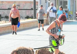 Una mujer pasea con sus dos perros.