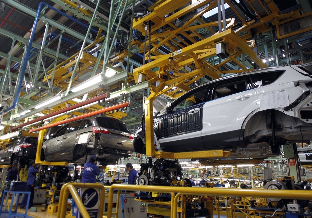 Varios trabajadores de la planta de Ford de Almussafes, en plena cadena de montaje de varios vehículos