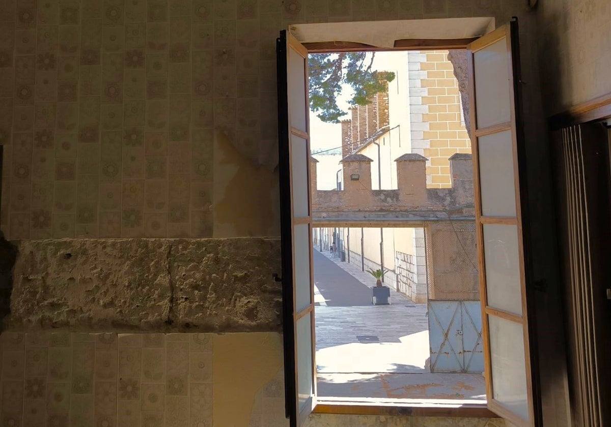 Detalle de un muro y las almenas, a través de una ventana.