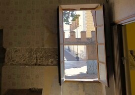 Detalle de un muro y las almenas, a través de una ventana.