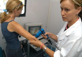 Una dermatóloga revisa la piel de una paciente.