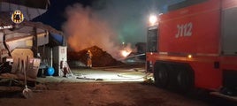 Los bomberos durante la extinción del incendio en la planta de Llíria.