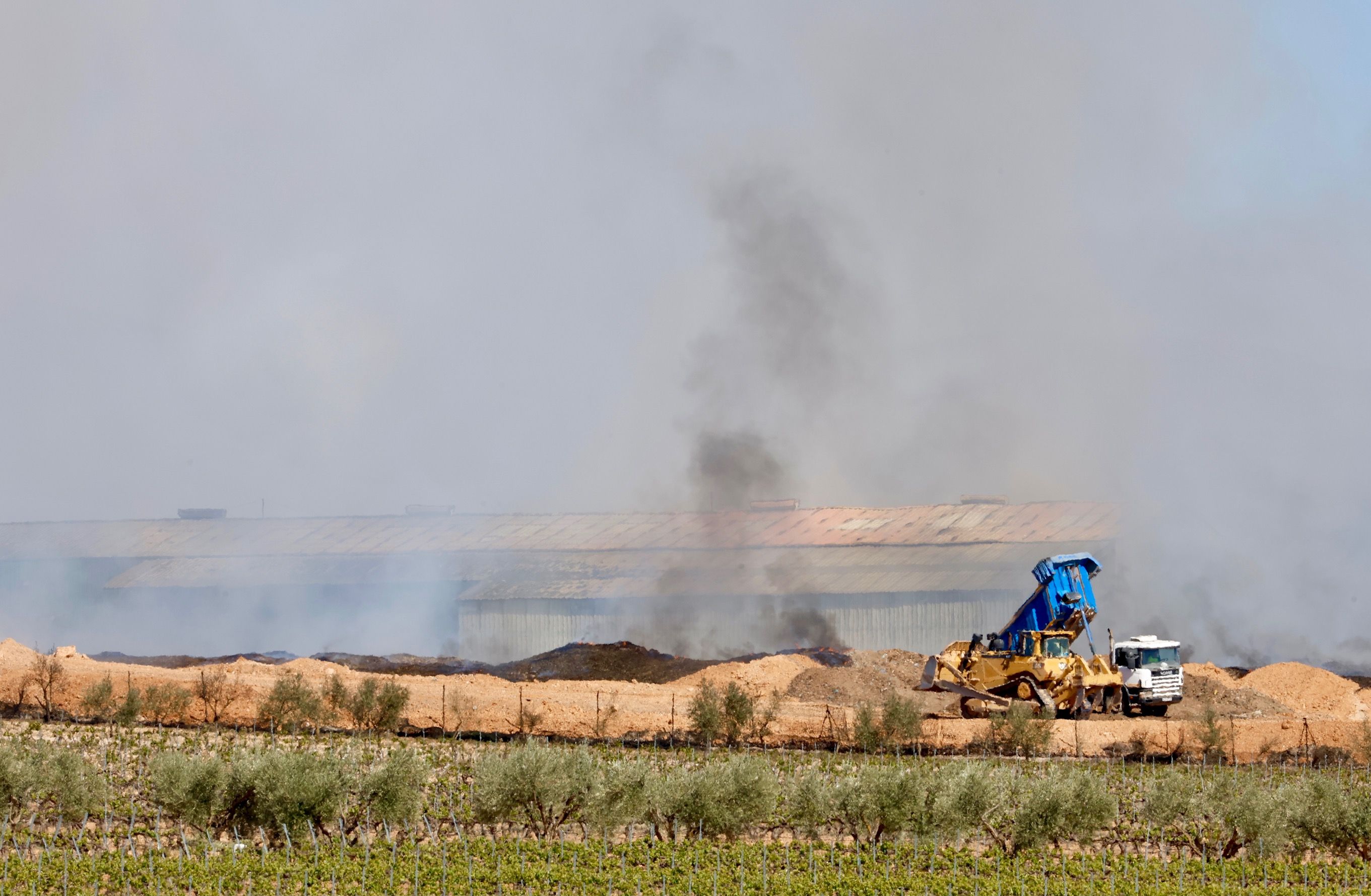 Maquinaria pesada para apagar el fuego de la planta de reciclaje de Requena