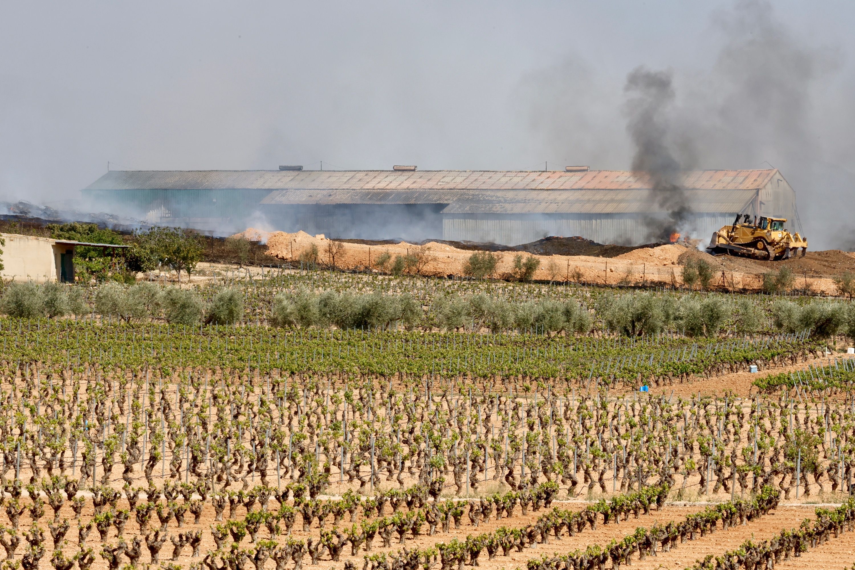 Maquinaria pesada para apagar el fuego de la planta de reciclaje de Requena