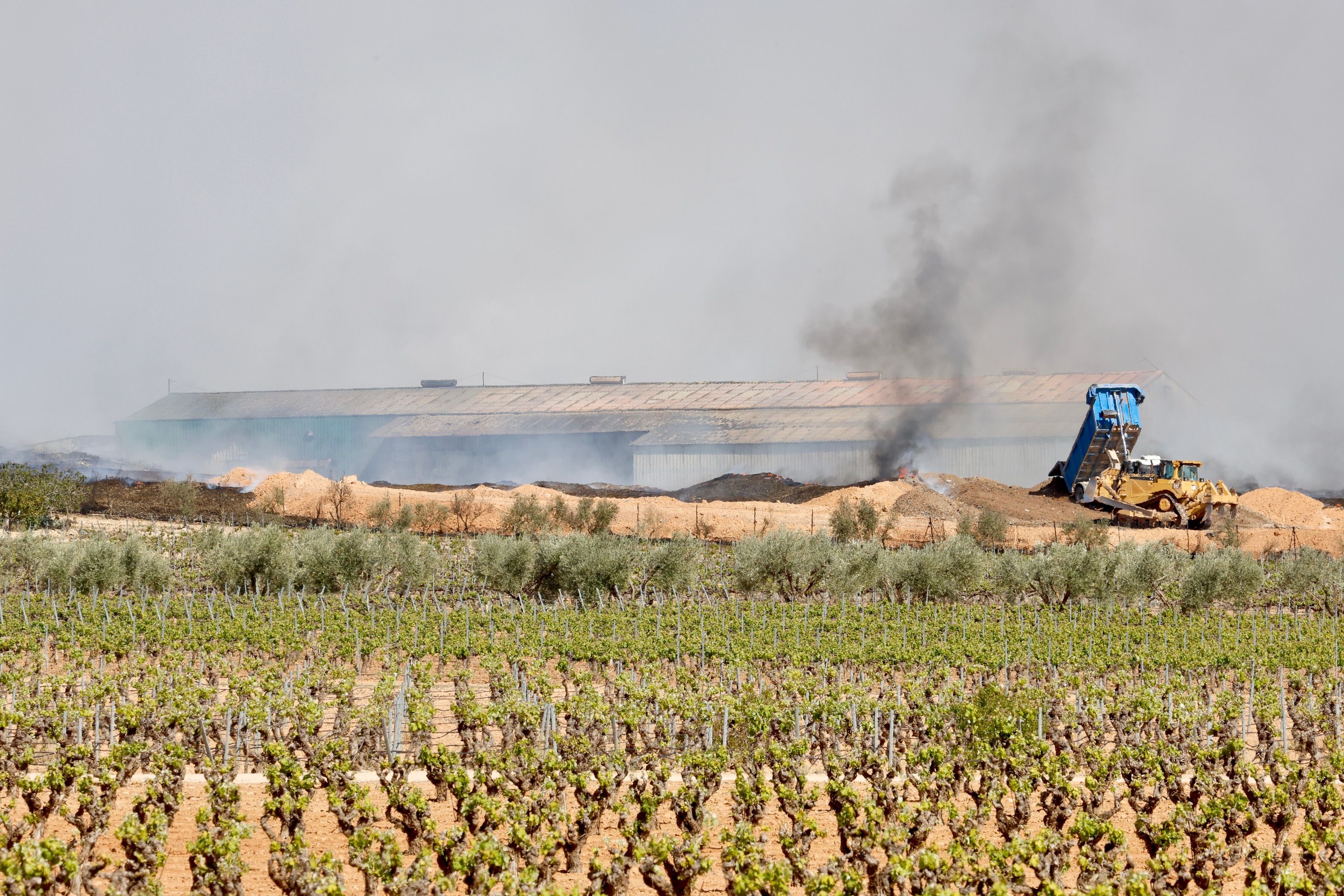 Maquinaria pesada para apagar el fuego de la planta de reciclaje de Requena