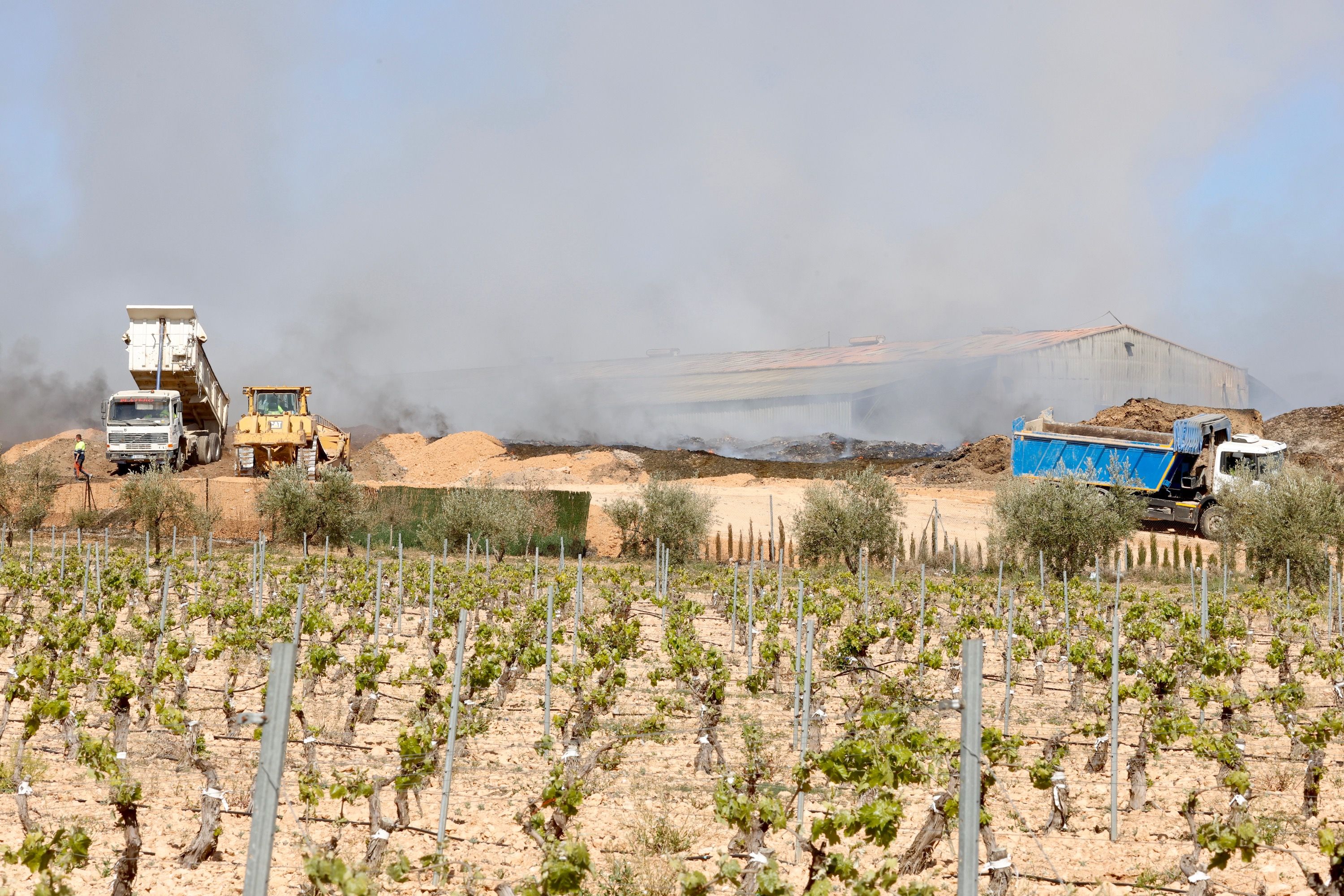 Maquinaria pesada para apagar el fuego de la planta de reciclaje de Requena