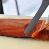 Un pescadero cortando salmón, imagen de archivo