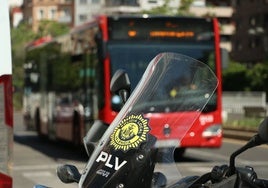 Una moto de la Policía Local, junto a un autobús de la EMT.