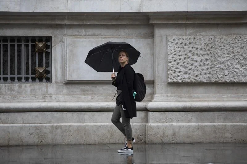 Una mujer se protege de la lluvia.