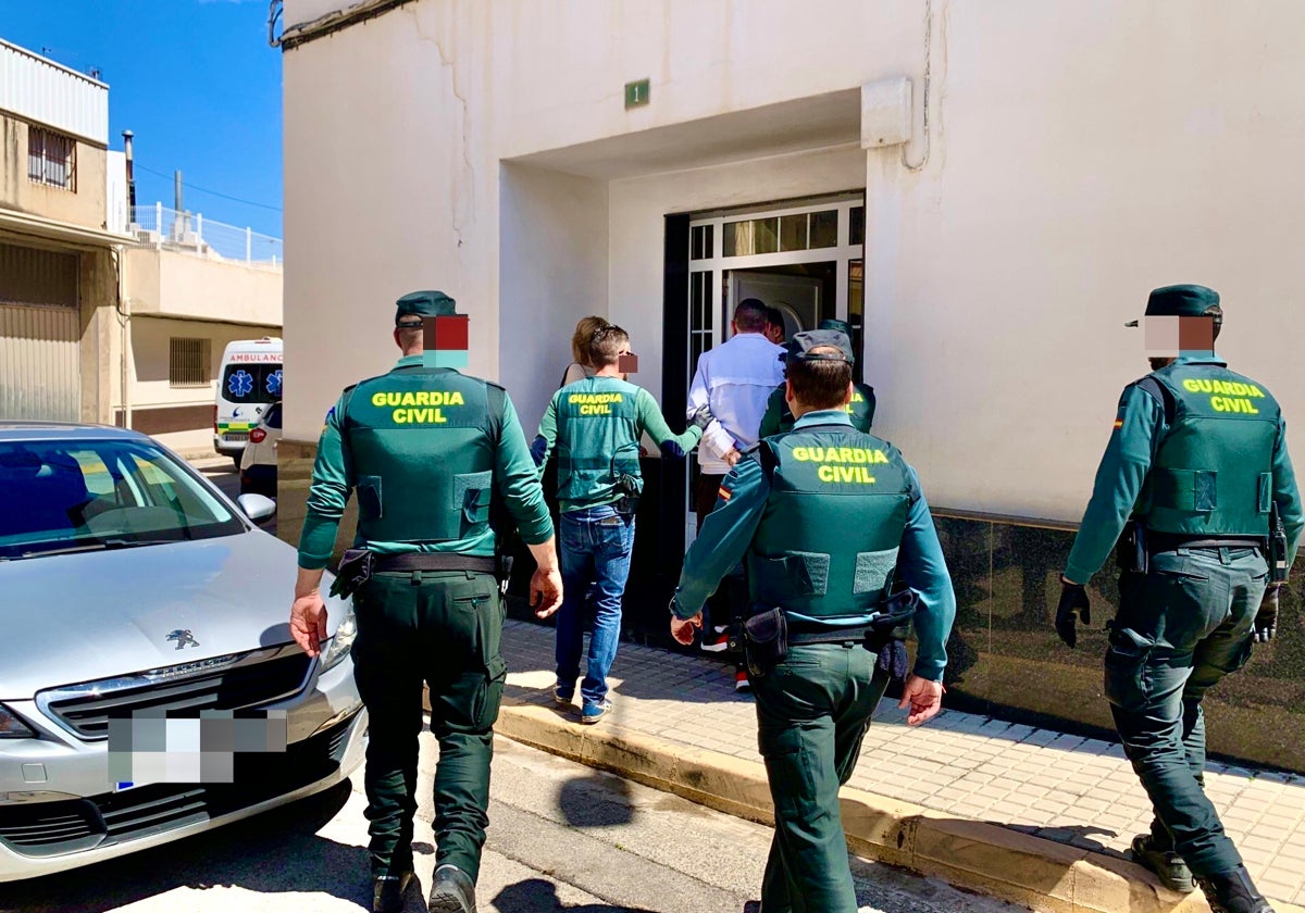 Varios guardias civiles entran en la casa de uno de los detenidos para registrarla.