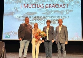 María Jesús Gamón, en el acto de reconocimiento agasajada con un ramoi de flores.