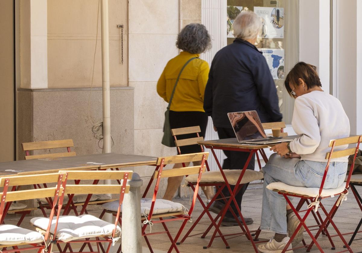 Una mujer, con su ordenador portátil en la terraza de un bar en Valencia.