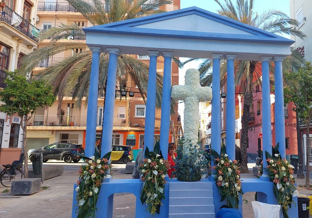 Cruz floral de la falla Plaza de la Cruz, homenaje al centenario del paseo de Neptuno, con la fachada del balneario de Las Arenas.