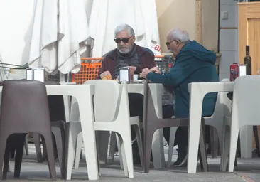 Dos hombres, sentados en la terraza de un bar en San Antonio de Benageber.