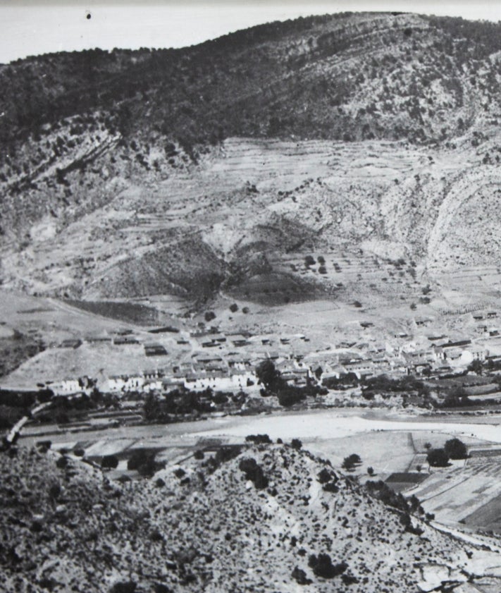 Imagen secundaria 2 - Eva Tejedor muestra una imagen que recuerda cómo era el aspecto de la plaza del antiguo San Antonio de Benagéber, cuyo ayuntamiento preside; sobre estas líneas, dos fotos en blanco y negro del viejo embalse.