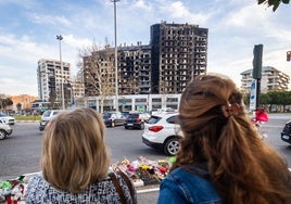 Dos mujeres observan el edificio incendiado de Campanar.