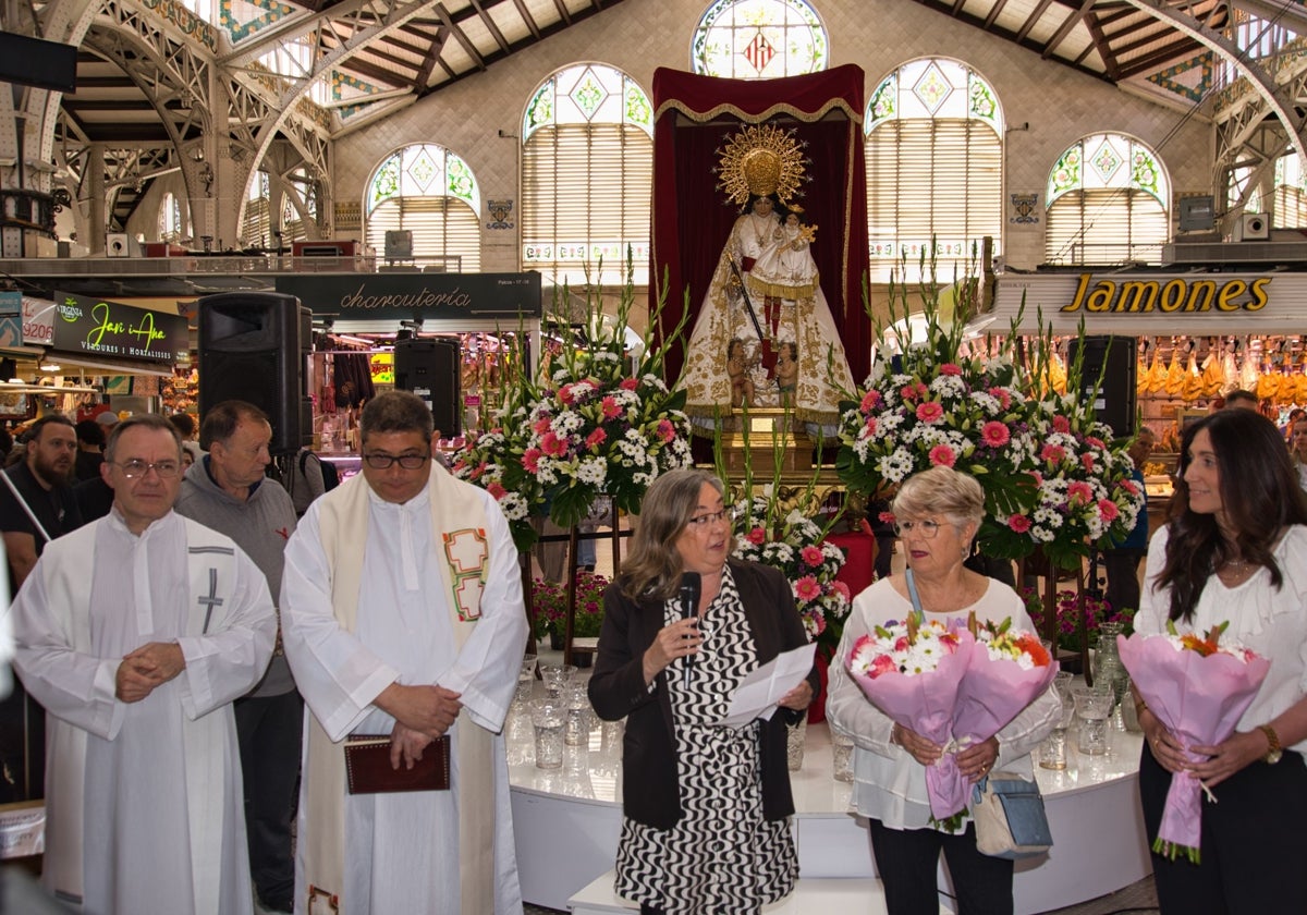 Cristina Oliete, gerente de la asociación de Vendedores del Mercado Central De Valencia, y párrocos de los Santos Juanes, en el acto en honor a la Virgen.