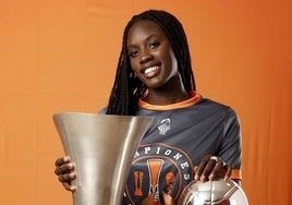 Awa Fam posa con los tres trofeos ganados por el Valencia Basket esta temporada.