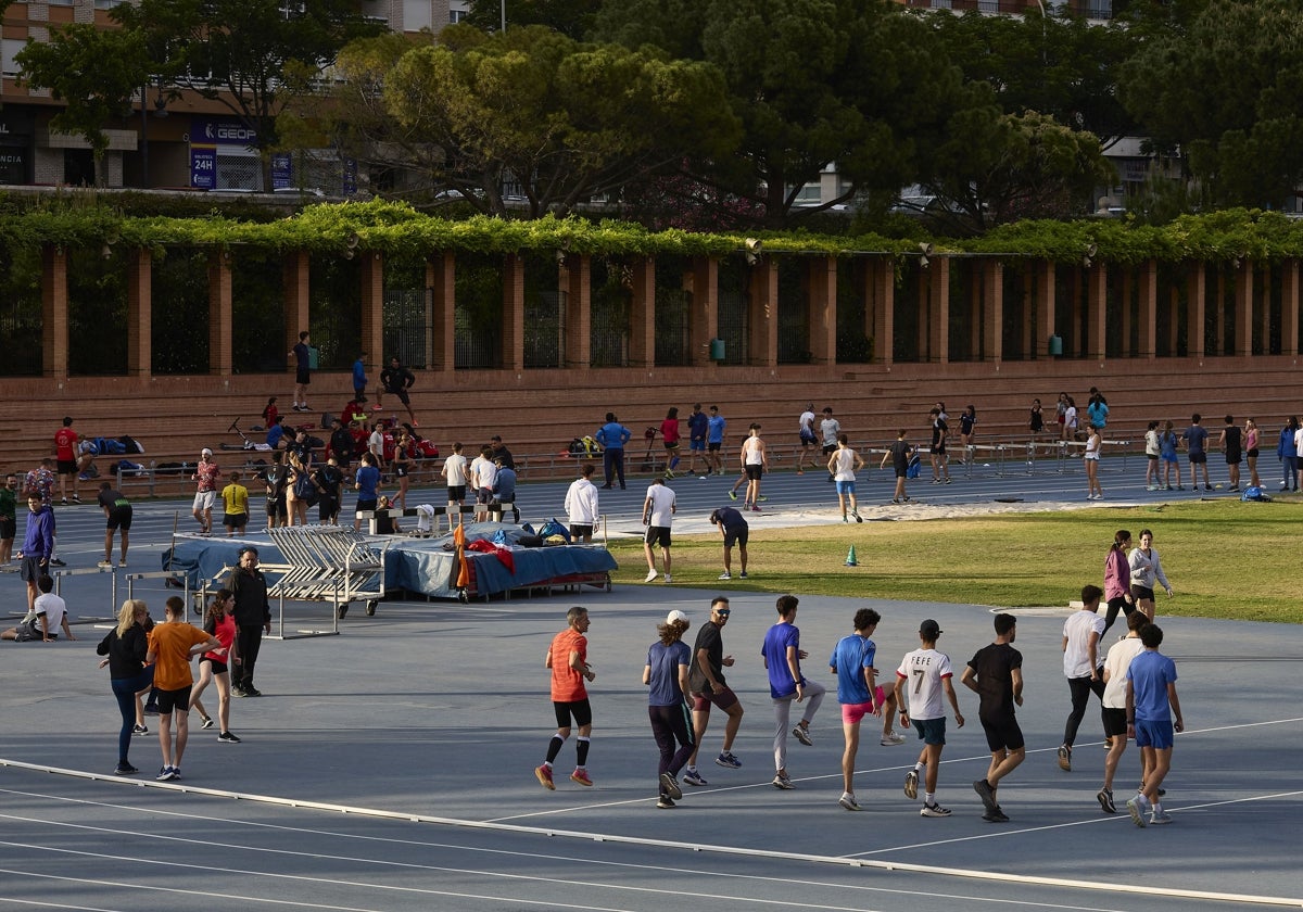 Deportistas entrenándose en la pista de atletismo del río Turia de Valencia.