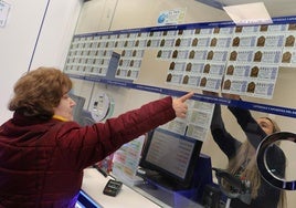 Una mujer compra un décimo en una administración de Lotería.