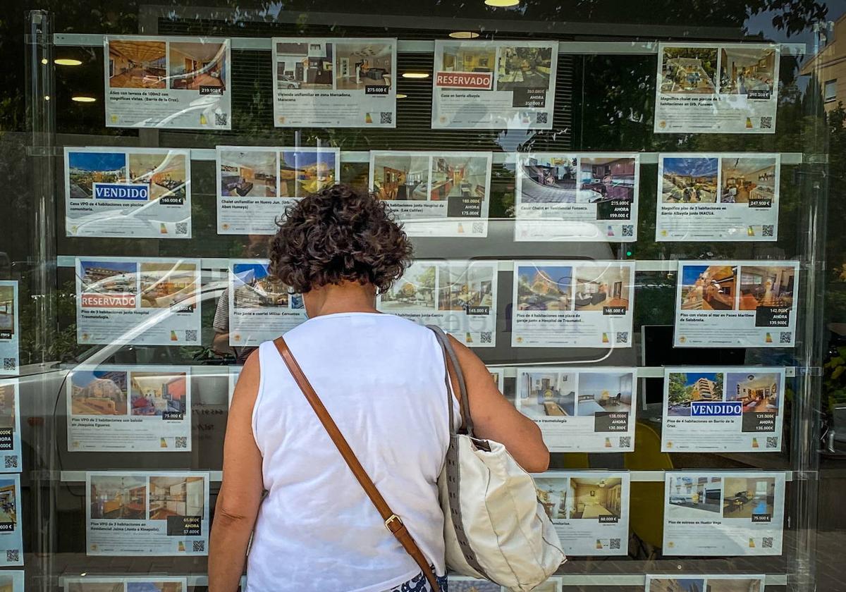 Una mujer mirando pisos en un inmobiliaria.