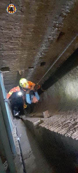 Un bombero saca al herido del pozo.