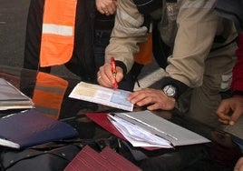 Implicados en una colisión múltiple firman los papeles del seguro tras el accidente, en una imagen de archivo.