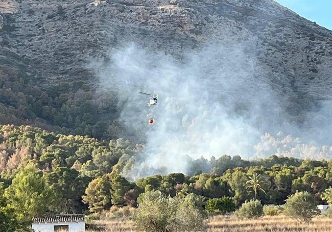 Uno de los helicópteros descargando en la zona del incendio.