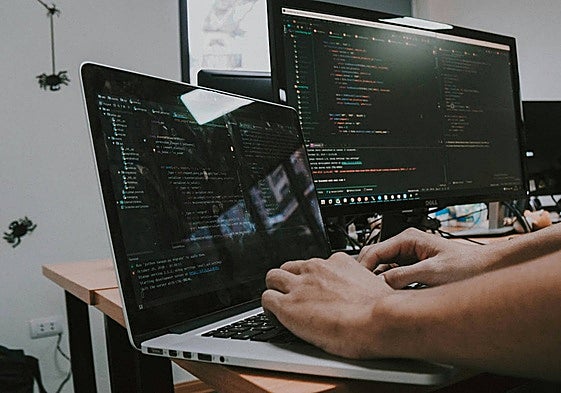 Un informático programando con un ordenador.