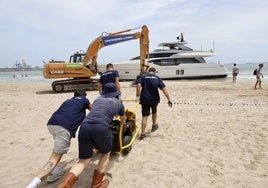 Una excavadora empieza a retirar la arena de la playa de Pinedo.