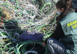 Una agente de la Guardia Civil inspeciona una maraña de cables durante una operación en la provincia de Valencia.