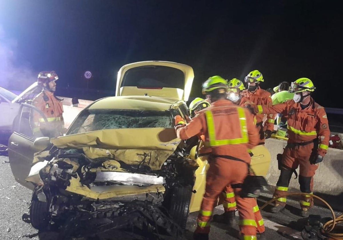 Los bomberos rodean el vehículo siniestrado en el accidente mortal de Beneixida.