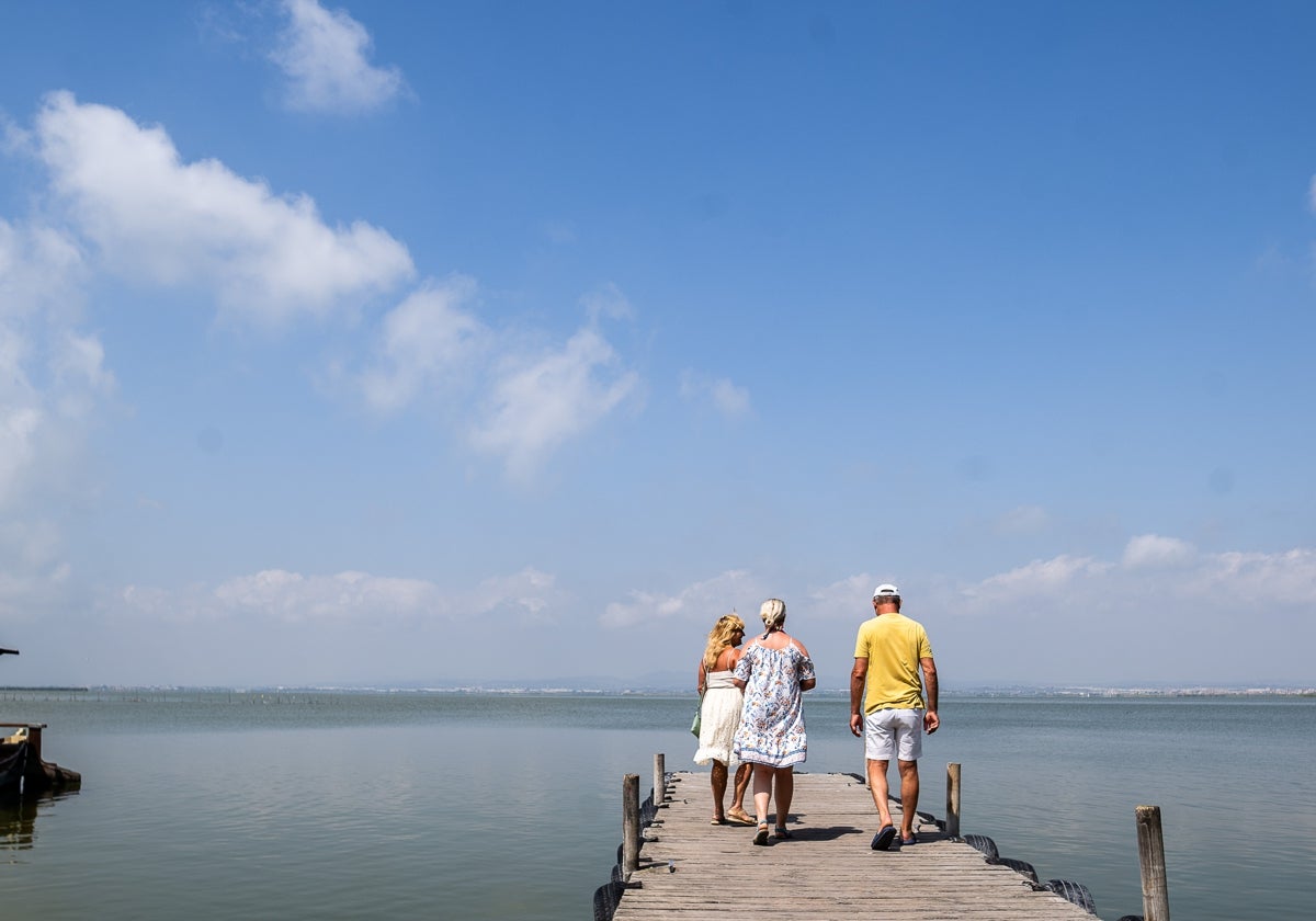 Visitantes en la Albufera, paseando por un embarcadero.