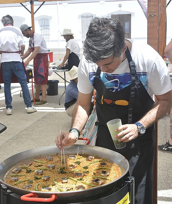 Imagen secundaria 2 - Arriba, los ganadores de esta tercera edición. A la izquierda, el jurado probando uno de los arroces. Este año se tenía en cuenta, además, el emplatado. A la derecha, uno de los concursantes, terminando su elaboración.
