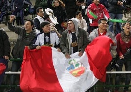 Aficionados con la bandera de Perú.