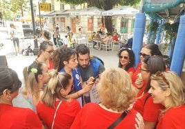 Voluntarios de la campaña hablan con las participantes en una despedida de soltera en el barrio.