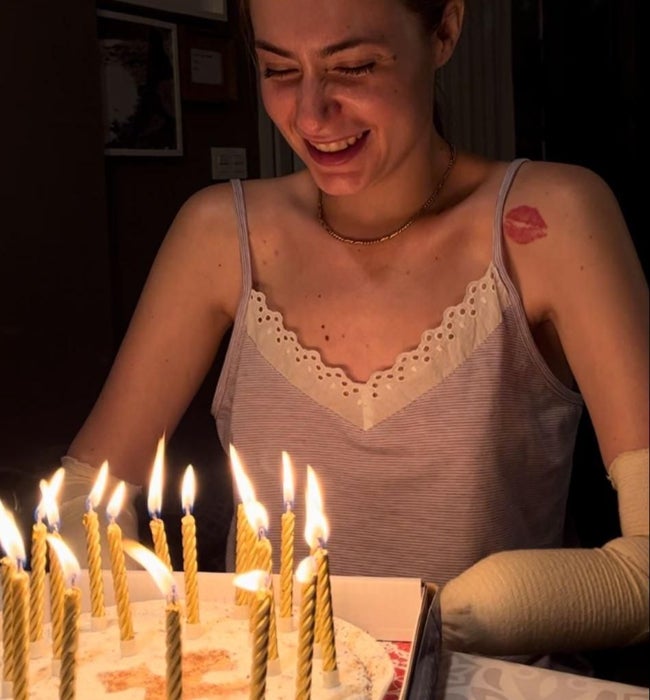 Carla sonríe junto a la tarta de su 26 cumpleaños que le llevaron sus amigos de la universidad.