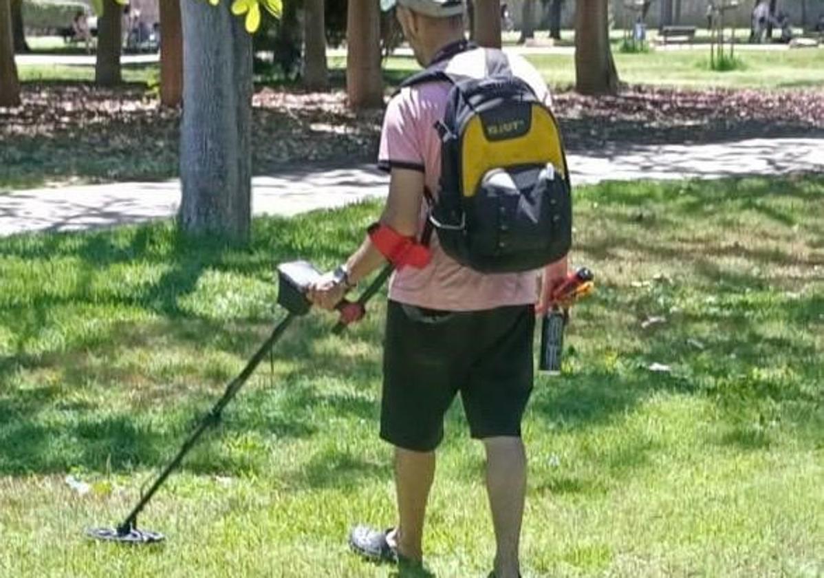 El hombre multado por la Policía Autonómica, con el detector con el que buscaba metales en el viejo cauce.