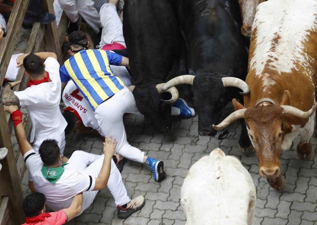 Imagen secundaria 1 - Sentir el pitón en la barriga y vivir para contarlo: la fortuna del mozo con la &#039;máscara de Mbappé&#039; en el encierro de Sanfermines