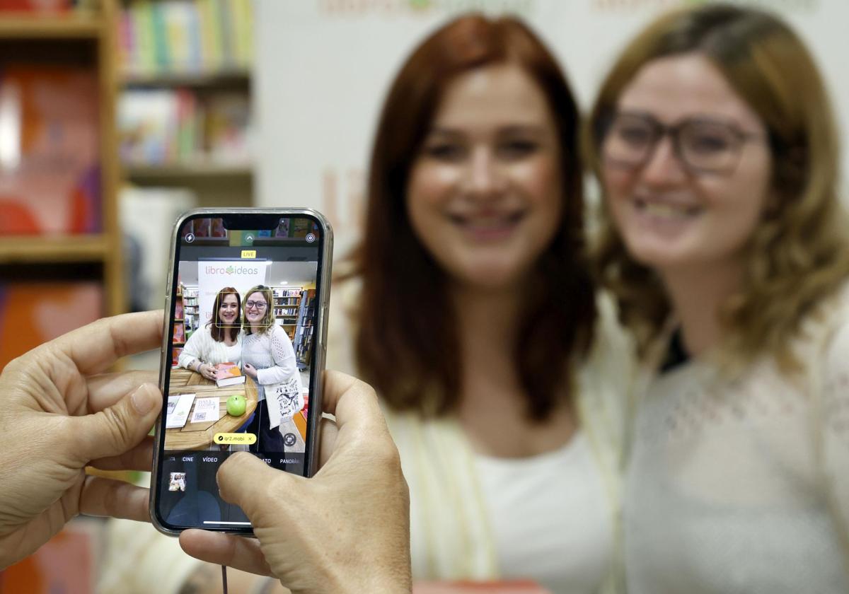 La cámara del móvil fotografía a Elísabet Benavent y una lectora.