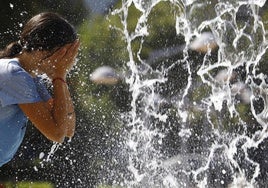 Una joven se refresca en un día caluroso.