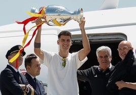 Morata levanta el trofeo en el aeropuerto de Barajas.